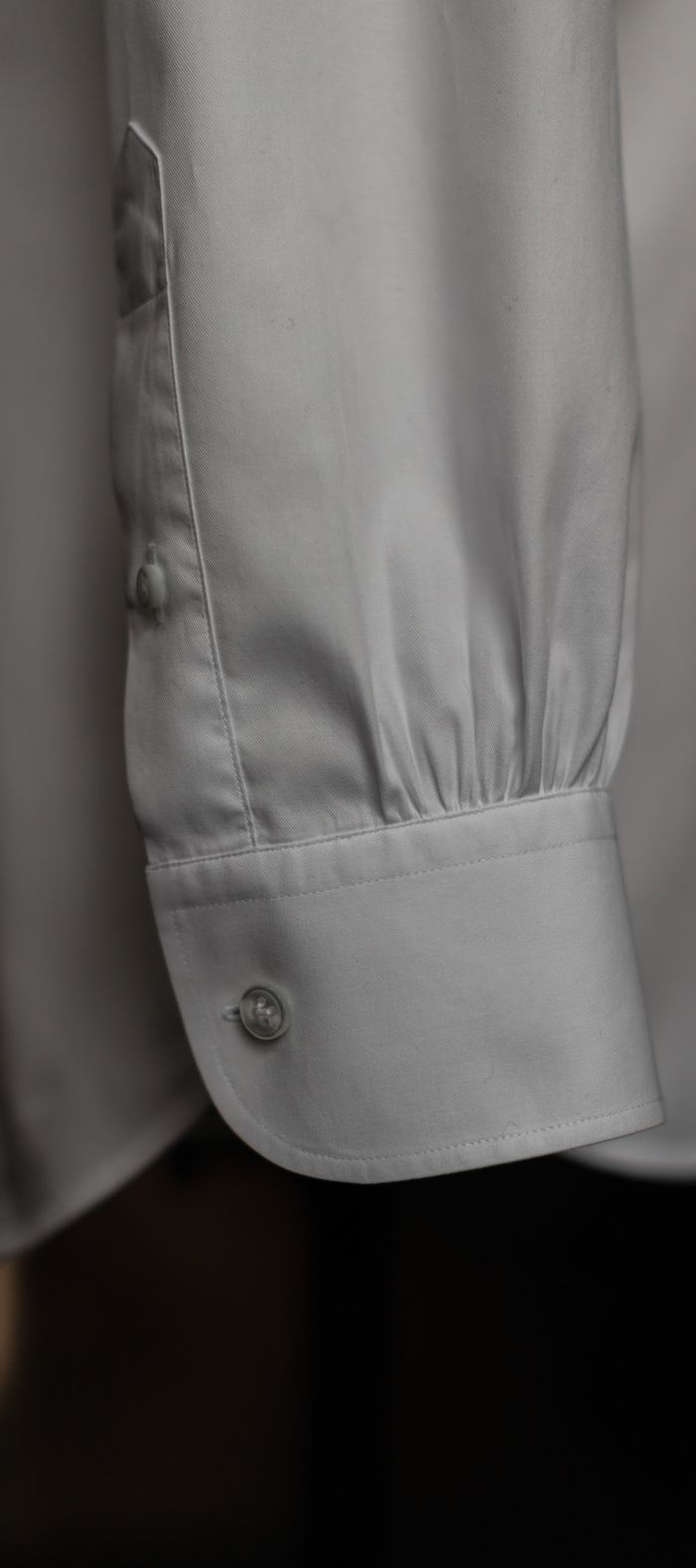 Punho de camisa branca abotoado