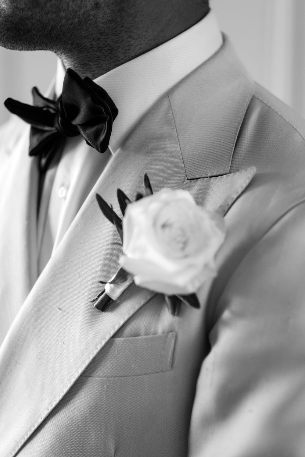 Dinner jacket lapel with a boutonnière and a silk bow tie