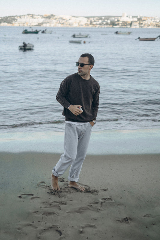 Man in a brown SuperGelong lambswool crew neck sweater by the sea, ATELIER 23