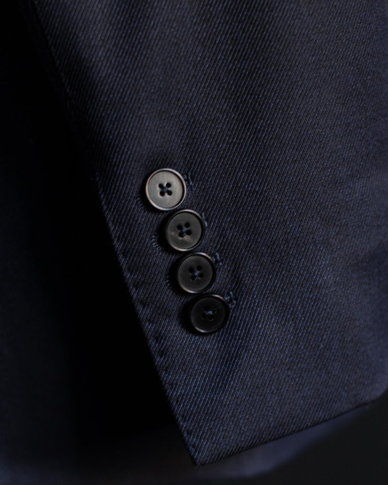 Four buttons on the sleeve of a navy jacket